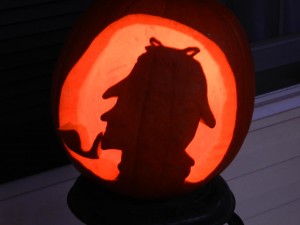 A pumpkin carved with the silhouette of Sherlock Holmes and his pipe 
