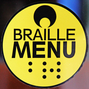 Image of a small yellow sticker with black writing that says Braille Menu and underneath in braille code, the word braille